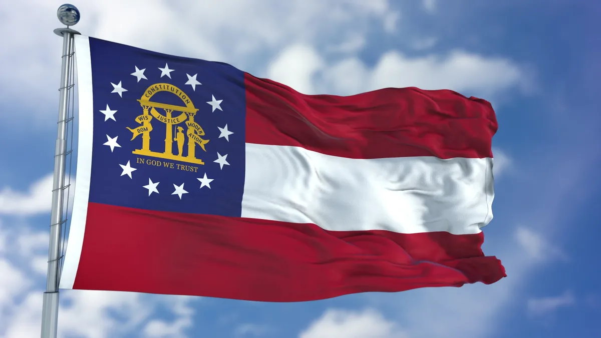 The Georgia state flag flying against a blue sky — best sporting clays ranges in Georgia